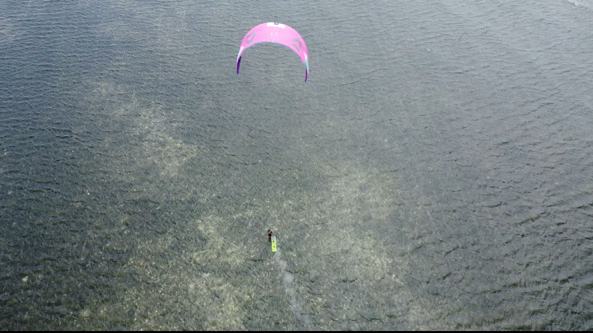Aerial view of a pink kite over turquoise water in the Philippines