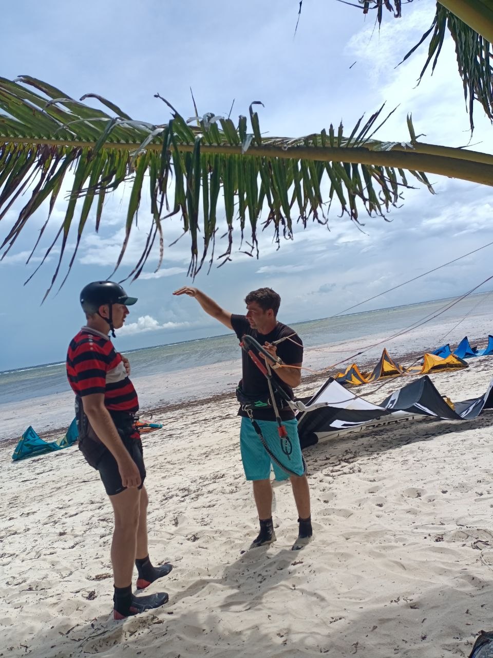 Kiter carving across flat Siquijor water with the kite loaded up