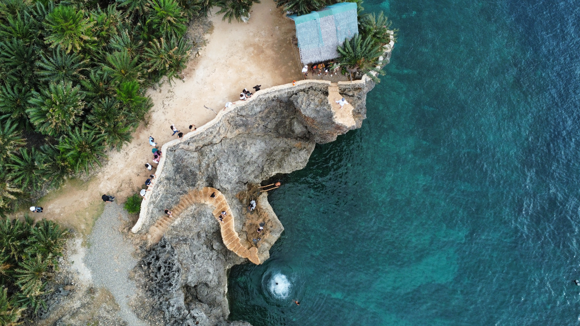 Aerial of a cliff jump spot with turquoise water