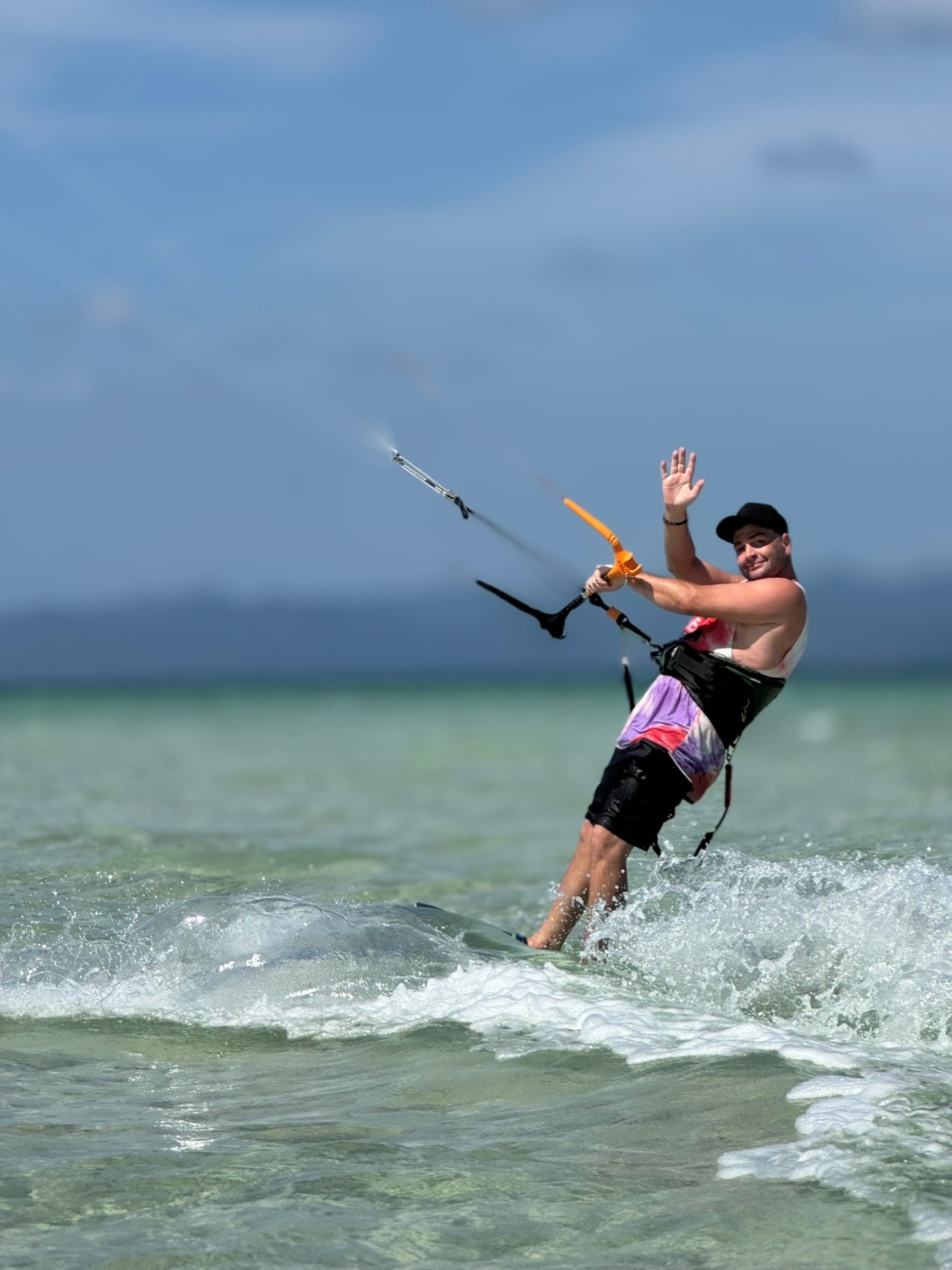 Kitesurfer waving on shallow turquoise water