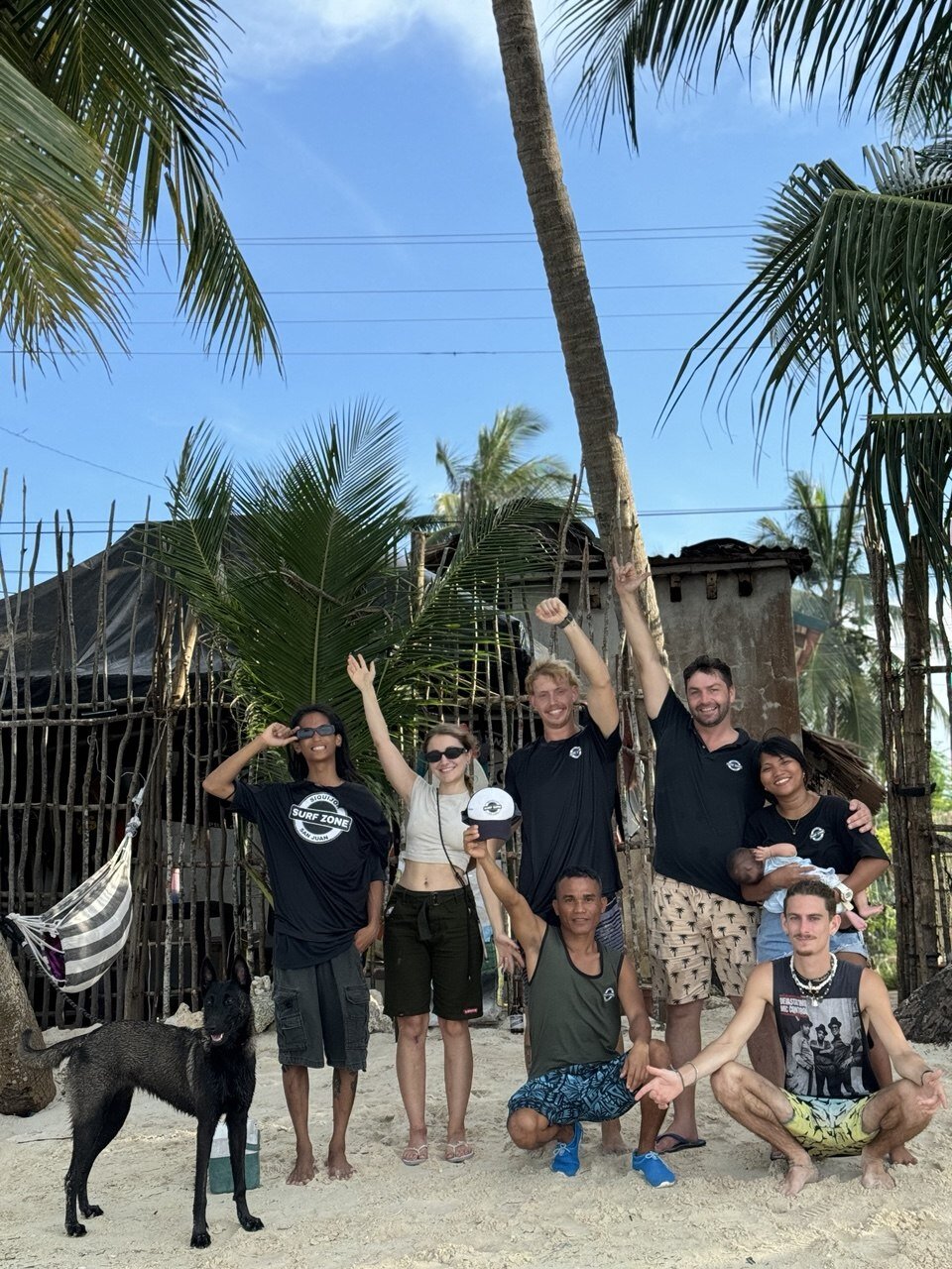 Surf Zone crew posing on the beach with the team dog